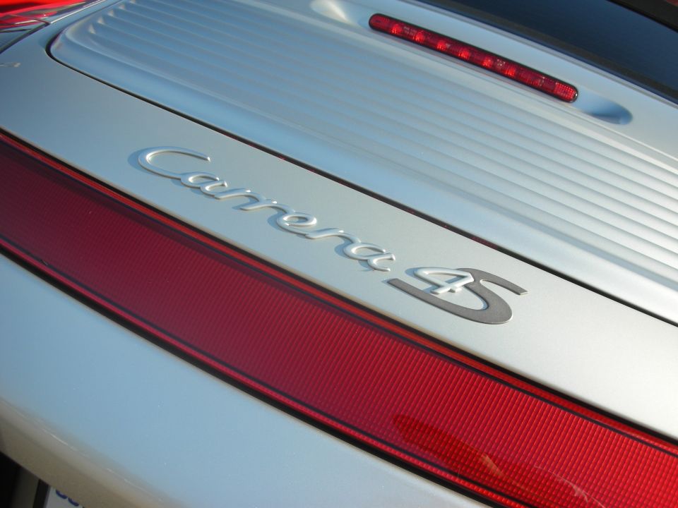 Silver Porsche 911 rear deck with chrome Carrera 4S badge and red taillight strip