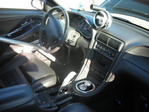 1998 Ford Crown Victoria - Modified car interior with racing seats, roll cage, and aftermarket gauges visible.