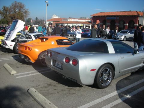 1998 Ford Crown Victoria - Silver Chevrolet Corvette at a car meet, with other vehicles present.