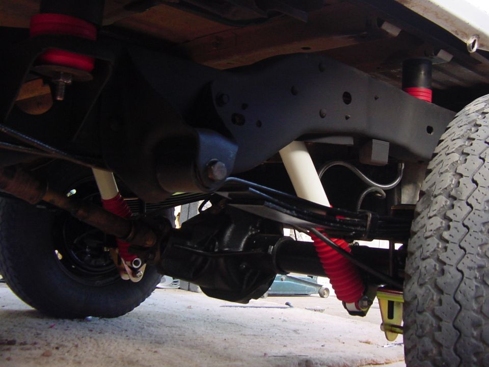 1992 Ford Bronco suspension with red and white shocks, leaf springs, and a differential