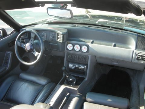 1998 Ford Crown Victoria - Fox body Mustang interior with aftermarket gauges and a manual transmission shifter.