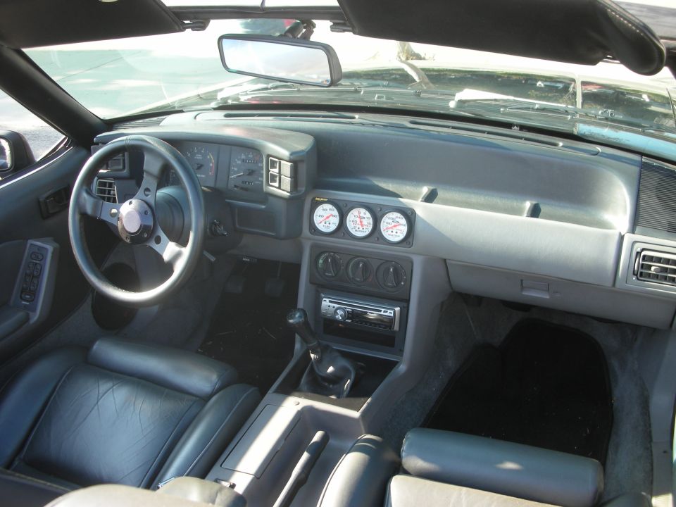 Fox-body Mustang convertible interior with gauges and aftermarket stereo