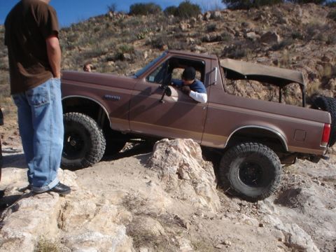 1989 Ford Bronco - This 1987 Ford Bronco is navigating a rocky off-road trail with a driver and passenger visible.