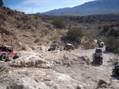 1989 Ford Bronco - Several off-road vehicles traverse a challenging, rocky terrain, their off-road capabilities.