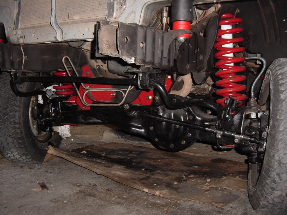 Close-up of red coil springs and black suspension parts on a vehicle