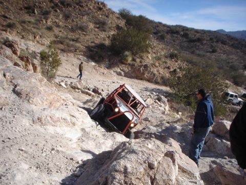 1989 Ford Bronco - Off-road buggy navigating difficult rocky terrain with onlookers present.
