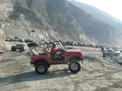 1987 Suzuki Samurai - A group of off-road vehicles gathered in a sandy, mountainous area.