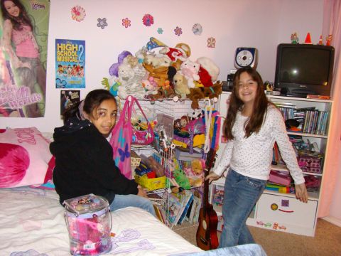 1989 Ford Bronco - A bedroom scene two girls surrounded by toys, posters, and books, with a guitar leaning against a shelf.