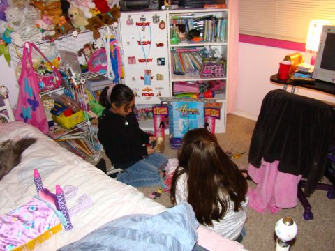 1989 Ford Bronco - Two girls are playing on the floor of a bedroom filled with toys and books.