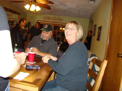 1989 Ford Bronco - A group of people are enjoying a card game indoors, with a "God Bless Our Home" sign on the wall.