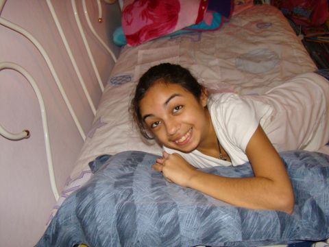 1989 Ford Bronco - A young girl smiles while lying on a bed with pillows and blankets.