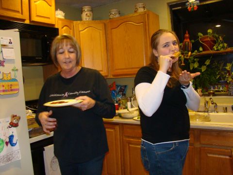 1989 Ford Bronco - Two women are in a kitchen, one holding a plate and the other eating.