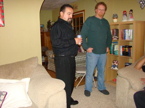 1989 Ford Bronco - Two men converse in a living room setting, with couches and a bookshelf visible.