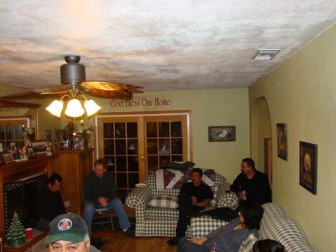 1989 Ford Bronco - A group of people are gathered in a living room, with a fireplace and a ceiling fan visible.