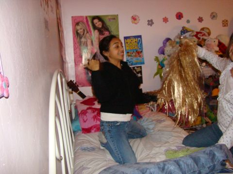 1989 Ford Bronco - Teenagers are playing with a wig in a bedroom decorated with posters and stuffed animals.