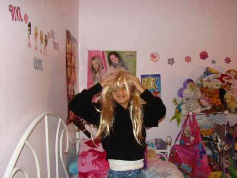 1989 Ford Bronco - A young girl plays dress-up in her bedroom, surrounded by posters and toys.