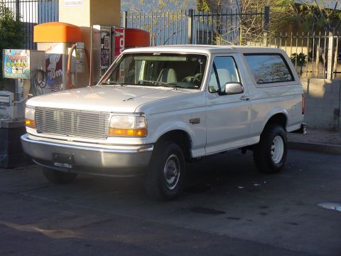 1992 Ford Bronco - A white 1992 Ford Bronco is seen from a three-quarter front angle at a gas station.