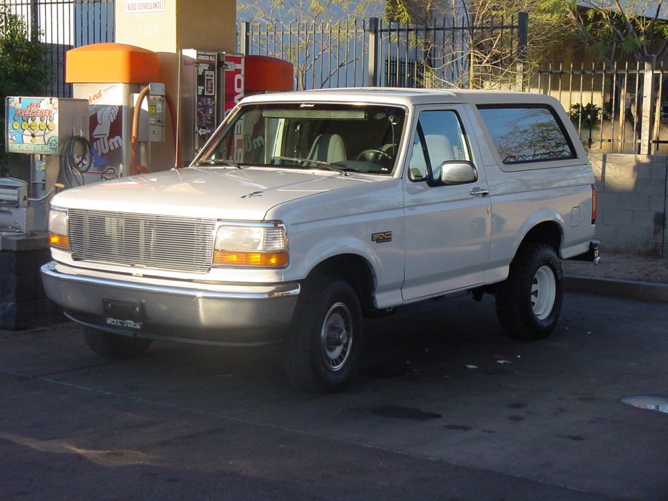 White 1992 Ford Bronco parked at a gas station