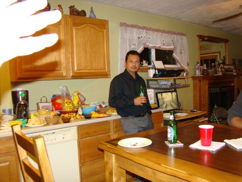 1989 Ford Bronco - A man stands in a kitchen holding a beer bottle, with food and drinks spread across the counter.