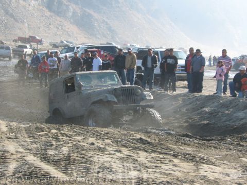 1987 Suzuki Samurai - Jeep stuck in mud with onlookers.