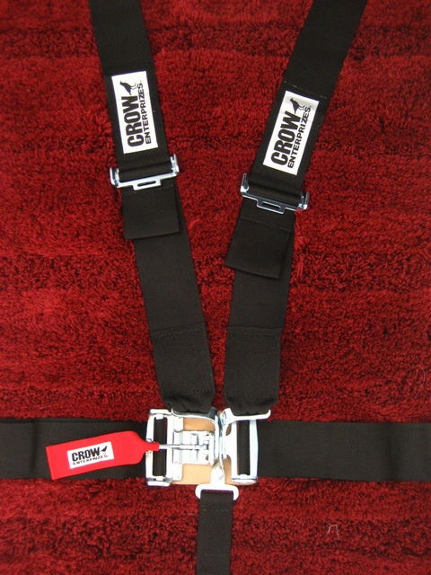1989 Ford Bronco - Black racing harness with "Crow Enterprises" branding on straps and a red tag.