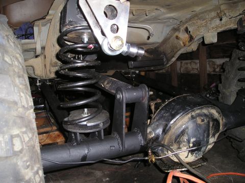 1986 Ford Bronco II - Custom suspension components are being installed on the rear axle of a vehicle.
