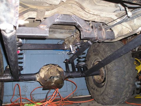 1986 Ford Bronco II - Custom suspension work is being done on the rear axle of a vehicle, with welding visible on the frame.