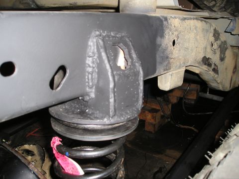 1986 Ford Bronco II - Close-up view of a vehicle's suspension system, showing the frame and a coil spring.