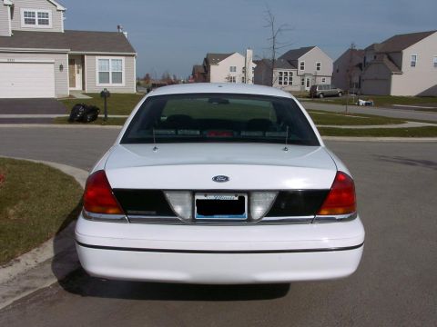 1999 Ford Crown Victoria - Rear view of a white Ford Crown Victoria, showing its taillights and black trim panel.