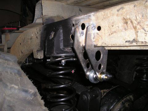 1986 Ford Bronco II - Close-up view of a custom suspension linkage and coil spring assembly, likely part of an off-road modification.