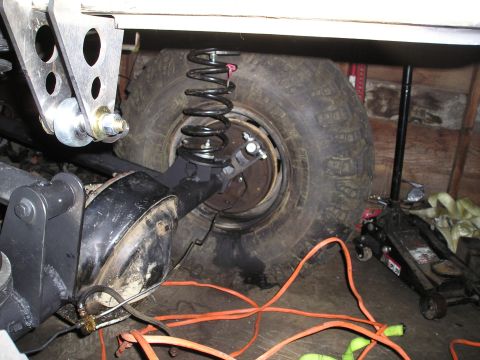 1986 Ford Bronco II - Rear suspension components and tire are visible, with a floor jack nearby.
