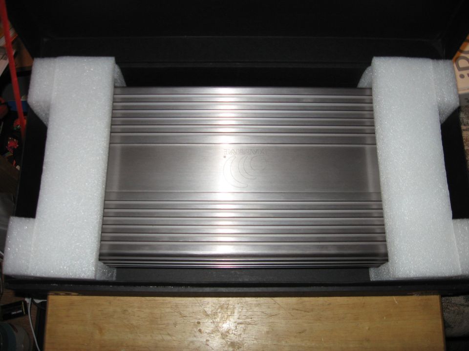 Car amplifier with ribbed metal casing, packed in foam inside a black box