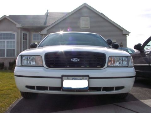1999 Ford Crown Victoria - Front view of a white 1999 Ford Crown Victoria, its grille and headlights, with an Illinois license plate visible.