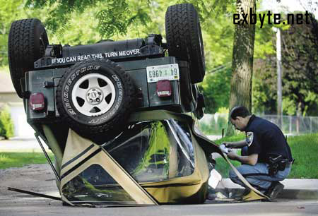 1979 Chevrolet Blazer - Jeep Wrangler overturned on its side, with a person in uniform inspecting the scene.