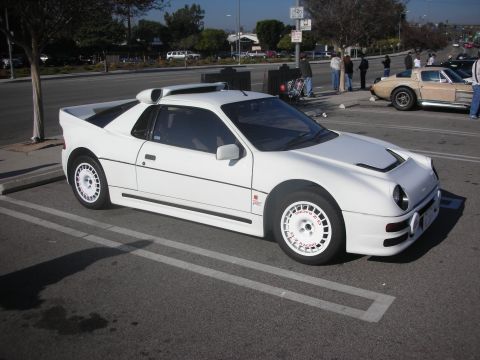 1998 Ford Crown Victoria - A white Ford RS200 is parked in a lot next to other vehicles.