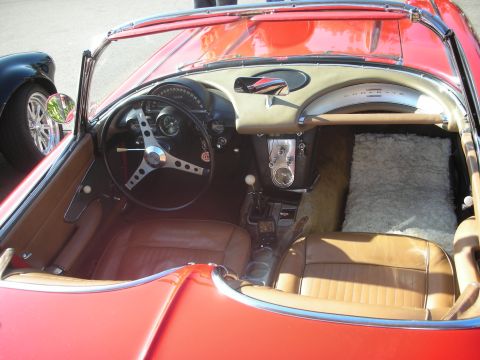 1998 Ford Crown Victoria - The interior of a classic red convertible shows tan leather seats and a detailed dashboard with a prominent steering wheel.