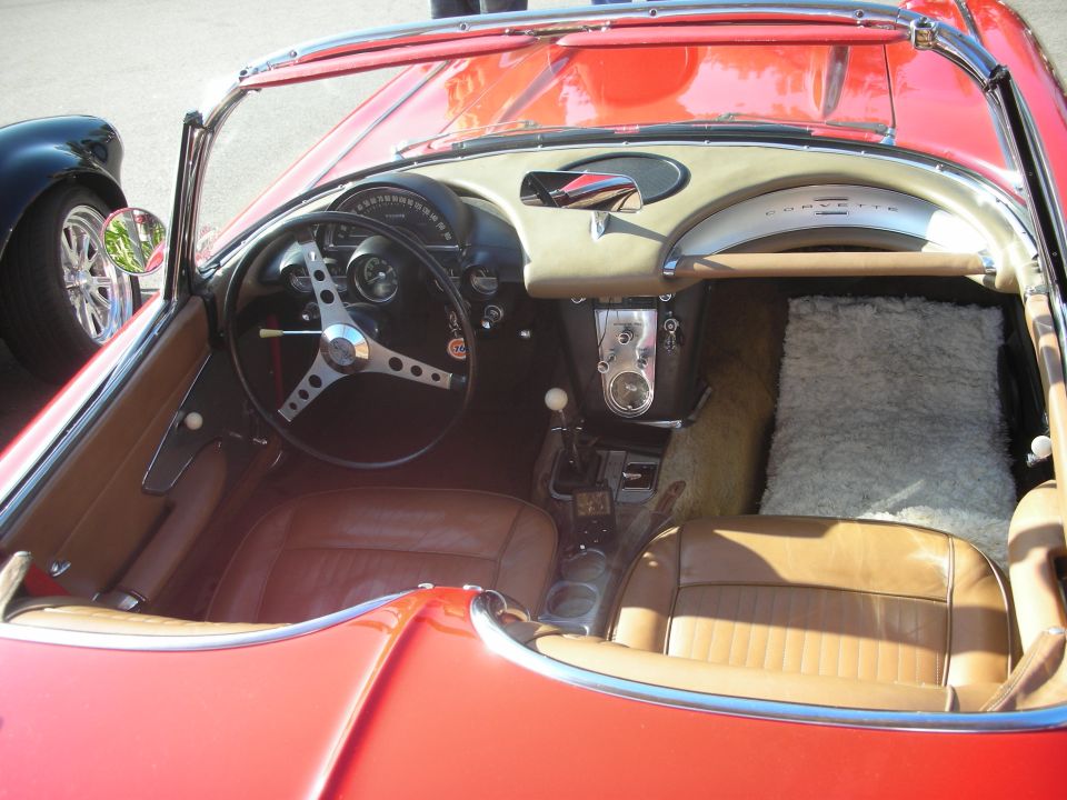 Cockpit of a red C1 Chevrolet Corvette with tan leather and CORVETTE script