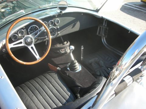 1998 Ford Crown Victoria - The interior of a classic AC Cobra features a wood steering wheel and black leather seats.