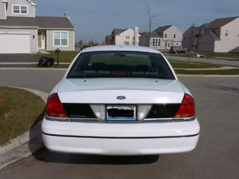 1999 Ford Crown Victoria - White Ford Crown Victoria sedan seen from the rear on a residential street.