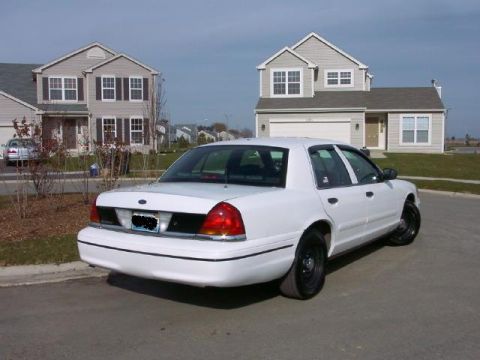 1999 Ford Crown Victoria - Rear view of a white 1999 Ford Crown Victoria parked on a suburban street.