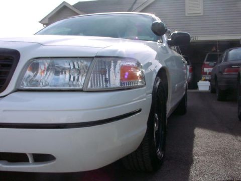 1999 Ford Crown Victoria - Front corner view of a white 1998 Ford Crown Victoria, showing its distinctive headlights and black trim details.