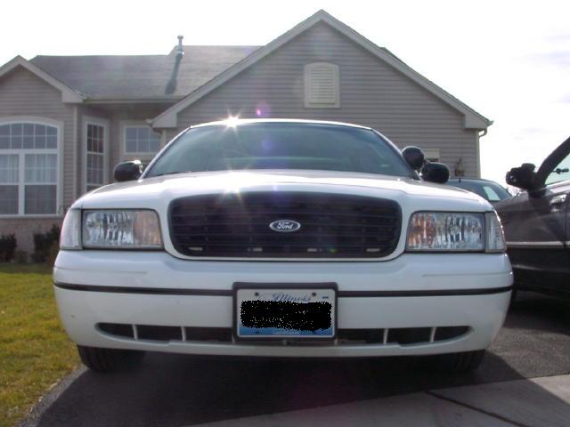 1999 Ford Crown Victoria front view, parked in driveway. Another vehicle is visible to the right