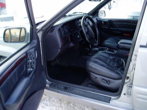 2000 Ford E350 - The interior of a Jeep Grand Cherokee is visible with its leather seats and dashboard.