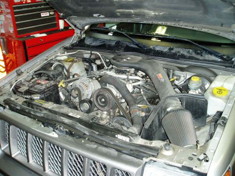 2000 Ford E350 - The engine bay of a vehicle, an aftermarket air intake system and various engine components.