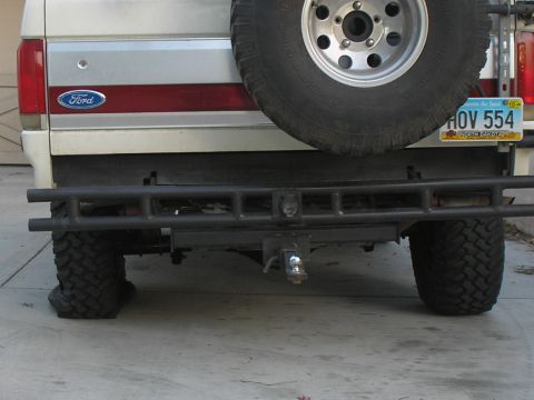 1990 Ford Bronco - The rear of a Ford Bronco shows a spare tire and a custom bumper, with a North Dakota license plate visible.