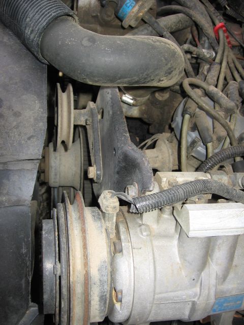 1987 Ford Bronco - Close-up view of engine components including pulleys and hoses.