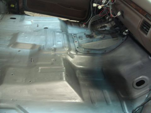 1996 Ford Bronco - The bare metal floor of a car interior, showing exposed wiring and a section of the dashboard.