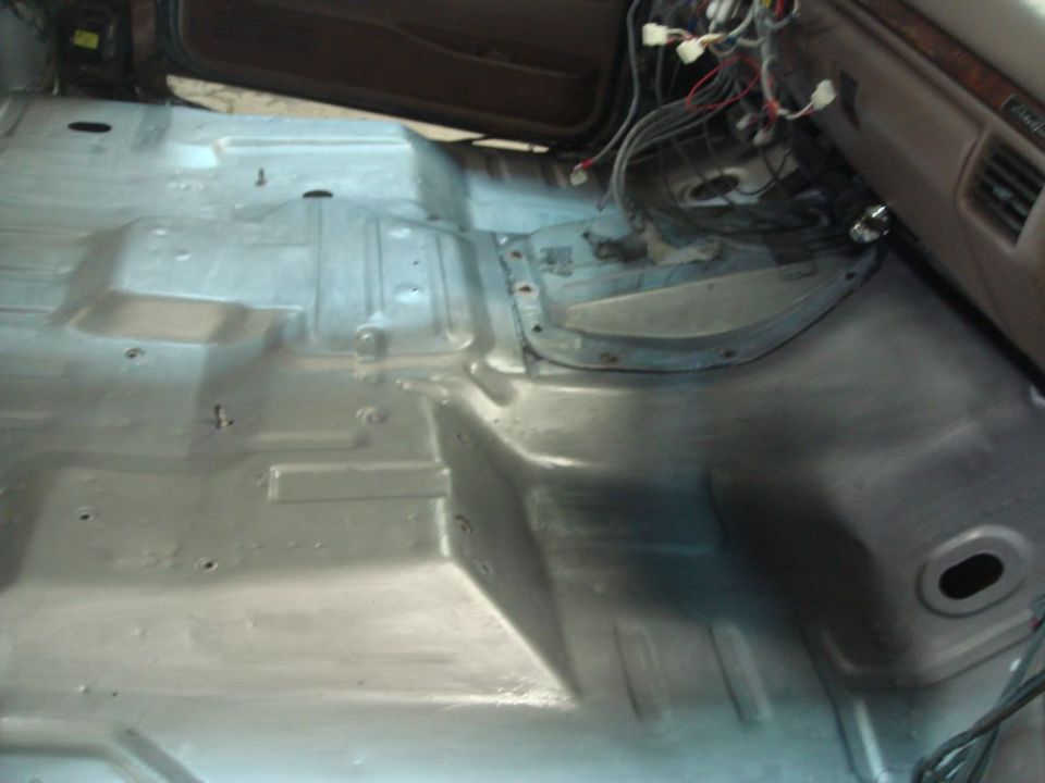 Car interior floor, gray, with exposed wiring and bare metal panels