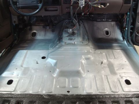 1996 Ford Bronco - The interior floor pan of a 1996 Ford Bronco has been stripped down to bare metal, revealing the underlying structure.