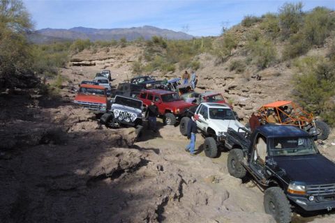 1994 Ford Bronco - A group of off-road vehicles navigates a challenging rocky terrain in a desert landscape.